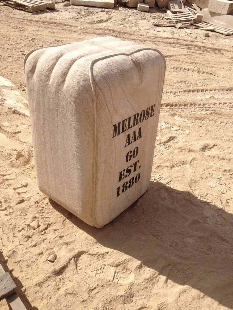 Wooden crate with MELROSE A LA GO EST. 1980 text stamped on side, sitting on sandy ground at construction site
