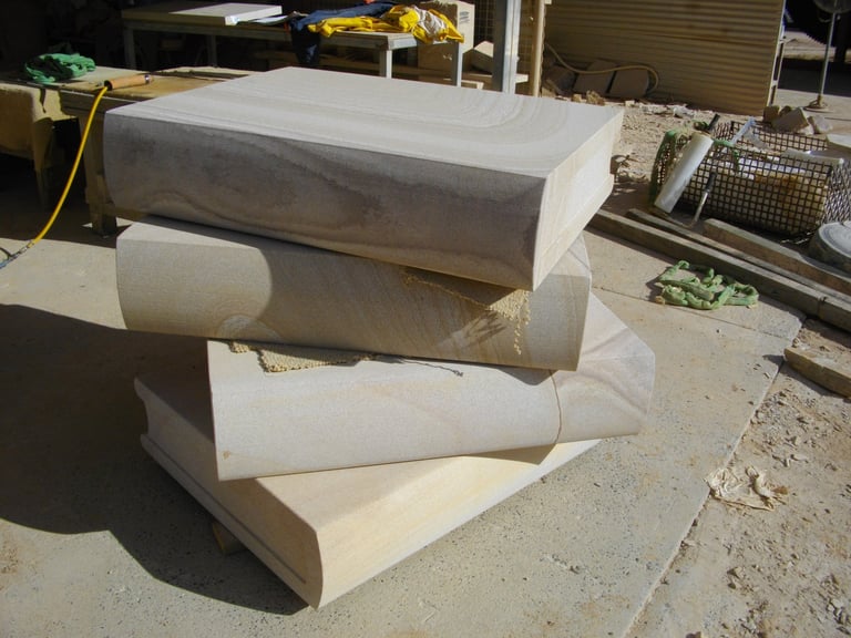 Stack of white foam or concrete cylindrical and rectangular blocks on outdoor concrete surface
